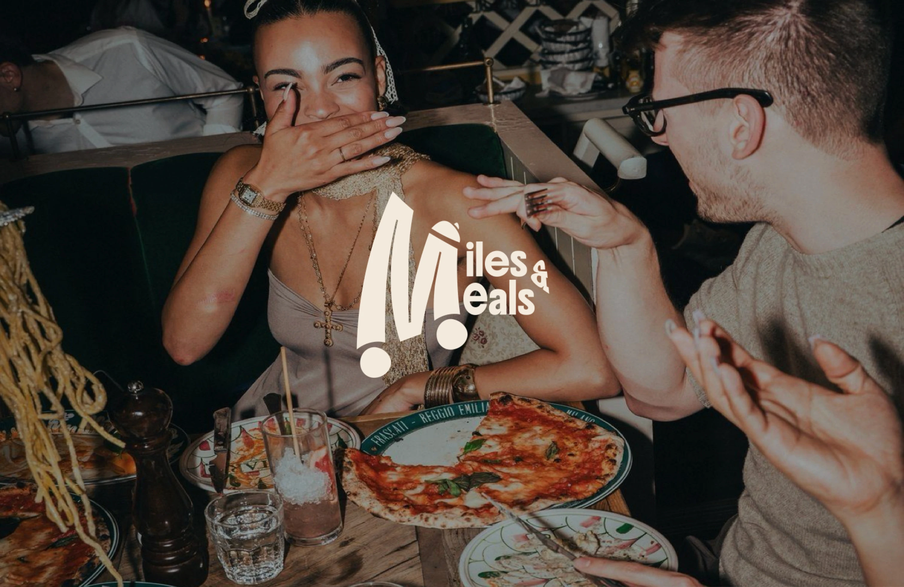 Friends laughing over pizza and pasta, with the Miles & Meals logo